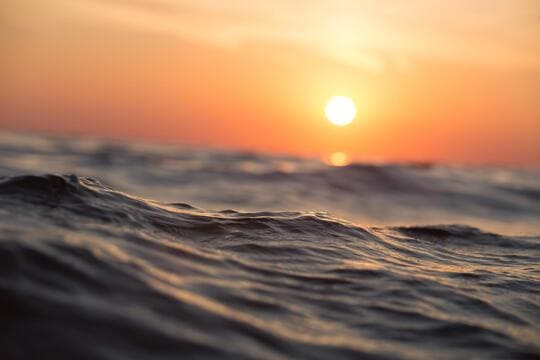 Sonnenuntergang und im Vordergrund die Wellen des Meeres